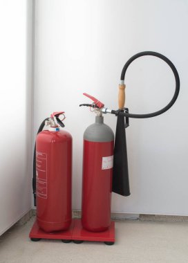 Two red fire extinguishers, water and CO2  in stand with instruction