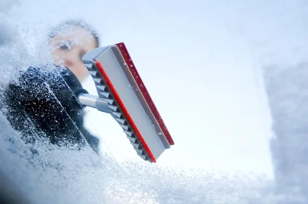 Winter driving - woman scraping ice from a windshield — Stock Photo, Image