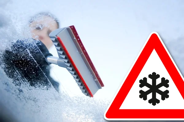 Winter driving - woman scraping ice from a windshield — Stock Photo, Image