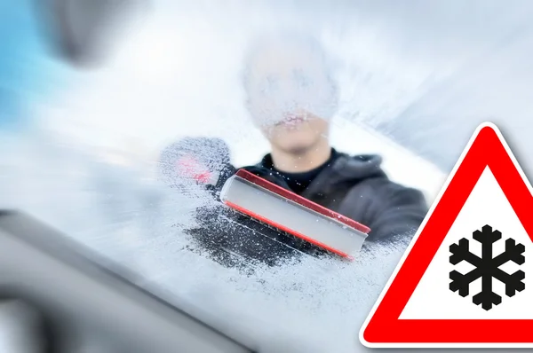 Winter driving - woman scraping ice from a windshield — Stock Photo, Image