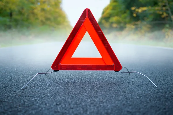 Vorsicht Nebel - Warndreieck auf nebliger Straße — Stockfoto