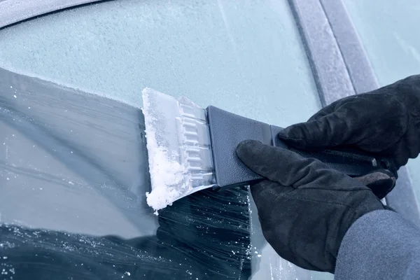 Condução de inverno - mulher que raspa o gelo de um pára-brisa — Fotografia de Stock