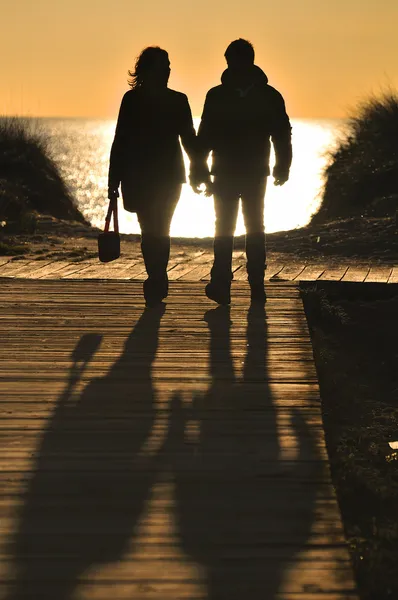 Paar geht am Strand spazieren — Stockfoto