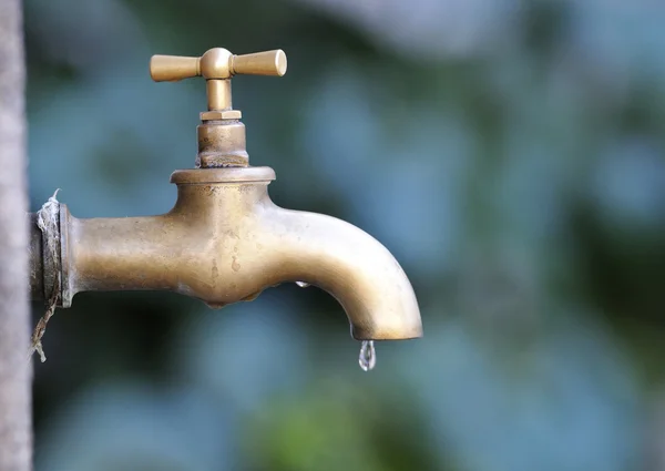 Torneira metálica com gota de água — Fotografia de Stock