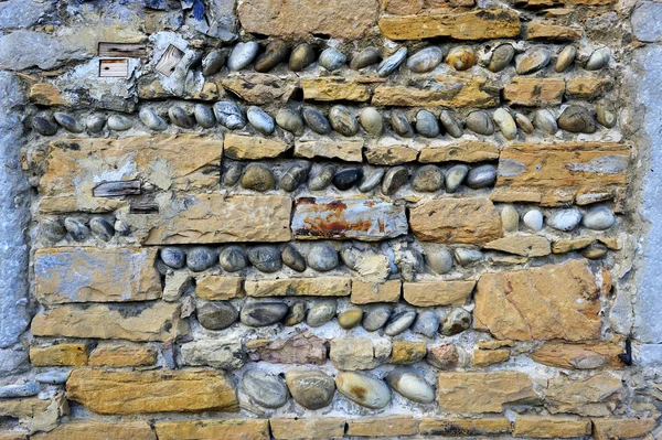 Wall of briks and round stones — Stock Photo, Image
