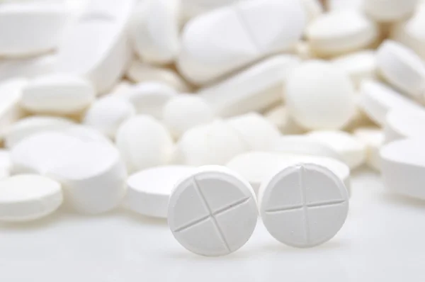 Heap de comprimidos redondos de medicamentos brancos — Fotografia de Stock