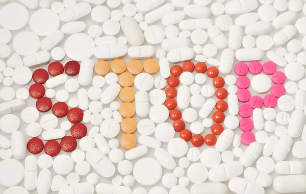 Comprimidos e drogas que formam a palavra STOP em inglês — Fotografia de Stock