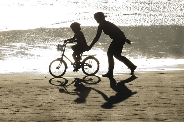 Mädchen lernt Fahrrad mit seiner Mutter lizenzfreie Stockbilder