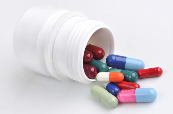 Capsules and tablets in canister — Stock Photo, Image