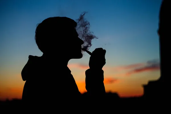 Foto Silhouette Uomo Irriconoscibile Con Pipa Fumante Maschio Accende Pipa — Foto Stock