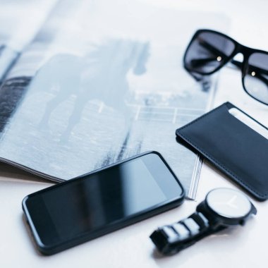 Ekolojik deriden alınmış şık, minimalist aksesuarların fotoğrafını çek. Kredi kartları, banknotlar, saatler, gözlükler ve cep telefonları için ince bir cüzdan. Moda adamı için siyah aksesuarlar.