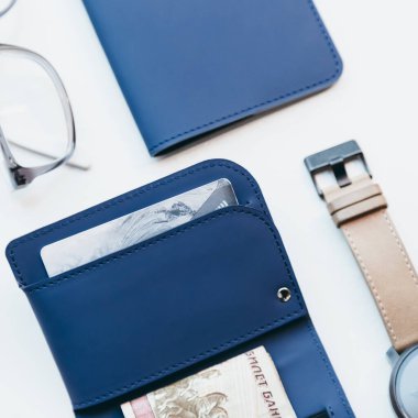 Banknotlar için mavi ince cüzdanın fotoğrafını çek ve pasaport ya da kimlik için de tutucuyu. Ekolojik deriden yapılmış el yapımı minimalist aksesuarlar. Bardakların ve el saatlerinin yanında..