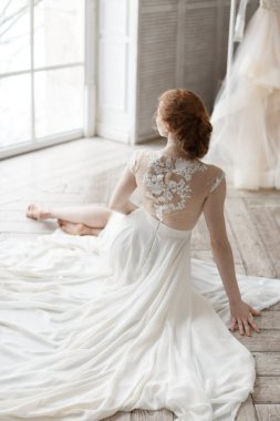 Krem rengi bir gelinlik içinde güzel bir gelinin dikey fotoğrafı. Evliliğe hazırlanıyor. Ciddi bir olay. Damadı bekliyorum..