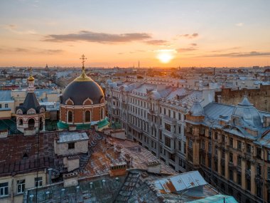 Aerial photo of Christian church and old beautiful residential buildings in historical center of Saint Petersburg, Russia. Sunset time. Rooftops of living houses. Wanderlust concept. clipart