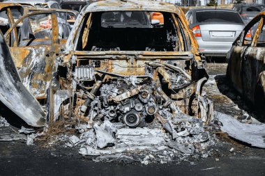 Destroyed engine and under the hood space of burned car. Metal remains of the automobile. Arson of a vehicle. Insurance case. clipart