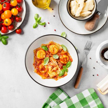 Ispanak ve ricotta ile doldurulmuş ev yapımı İtalyan mantısı domates sosu, parmesan peyniri ve taze fesleğen yaprağı ile servis edilir. Üst görünüm