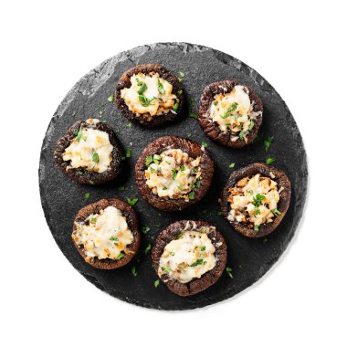 Tavuk eti, parmesan peyniri, sarımsak ve bitkilerle doldurulmuş fırında mantar kapları. Beyaz arka planda izole edilmiş. en üstteki görünüm