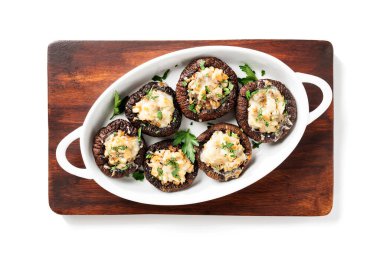 Tavuk eti, parmesan peyniri, sarımsak ve bitkilerle doldurulmuş fırında mantar kapları. Beyaz arka planda izole edilmiş. en üstteki görünüm