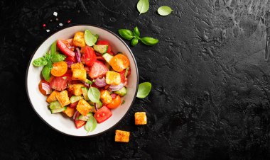 Toskana Panzanella, domatesli geleneksel İtalyan salatası ve kızarmış ekmek. Vejetaryen panzanella salatası. Siyah arka plan. Üst görünüm