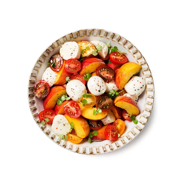 Mozzarella ve vişneli domatesli yaz şeftali Caprese salatası. Beyaz arkaplanda izole edilmiş, üst görünüm