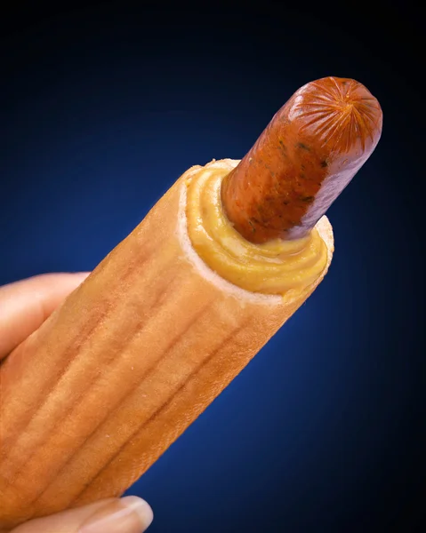 Tasty french hot dog with mustard on black background — Stock Photo, Image