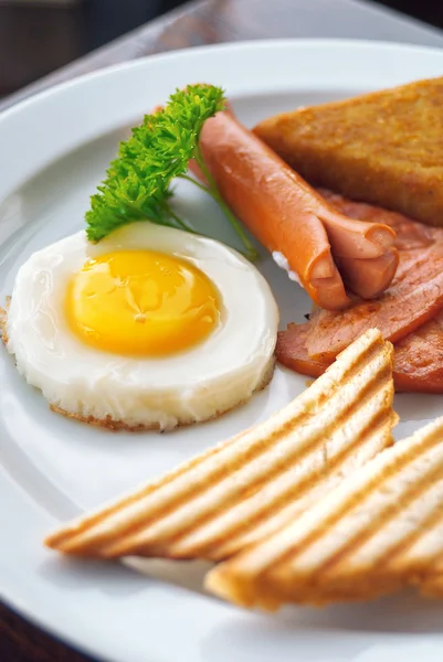 Desayuno inglés - huevos fritos, salchichas, frijoles, tocino y tostadas servidas con café —  Fotos de Stock