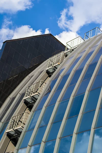 Футуристическое здание с зеркальным фасадом в голубом — стоковое фото