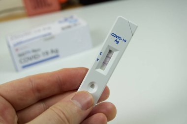 Pozitif bir antijen testi ve konteynır gösteriyor. CVID önleme ve teşhisi 