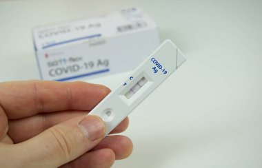Pozitif bir antijen testi ve konteynır gösteriyor. CVID önleme ve teşhisi 