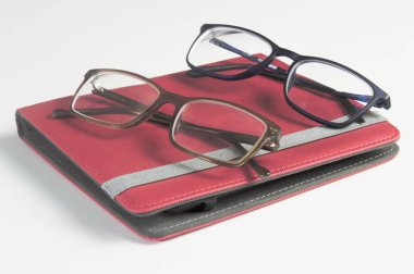 Gözlük ve kitap okuyucu gri beyaz arka planda izole edilmiş. Teknoloji kullanımı