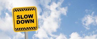 Mavi gökyüzü arkaplanındaki yavaşlama işareti