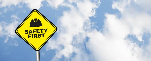 Yellow safety first sign on  blue sky background