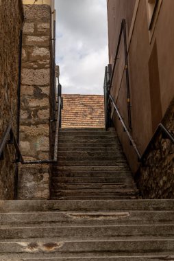 Macaristan 'ın Tapolca kasabasındaki eski kasaba binalarının olduğu eski taş merdivenlerin fotoğrafı.