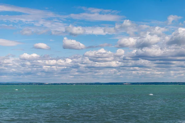 Macaristan, Siofok 'taki Balaton Gölü' nün fotoğrafı. Dramatik bulutlu gökyüzü ve mavi, suyu sarmala.