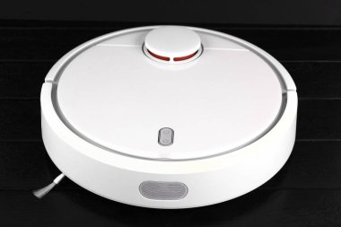 Siyah arka planda akıllı robot elektrikli süpürge beyazı, yakın plan. Robot elektrikli süpürge daireyi belirli bir zamanda otomatik olarak temizliyor. Akıllı Ev. Yüksek kalite fotoğraf
