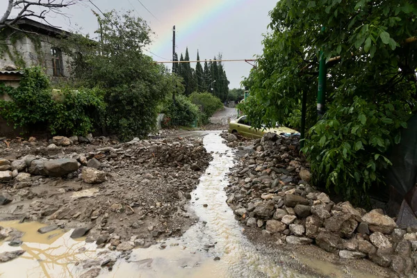 水や泥流の泥ストリームは 道路に沿って 破壊された 破損し 洪水の車や虹の背景に家を流れる 自然災害保険の概念 高品質の写真 — ストック写真
