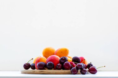 Beyaz arka planda izole edilmiş kayısılı tatlı kirazlar. Olgun böğürtlenler yakın çekim. Meyve ve böğürtlen.