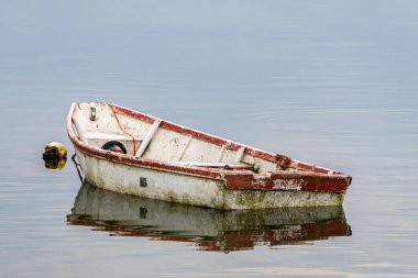 Reflection in the water of fishing boats standing on the pier in the sea bay. South Africa