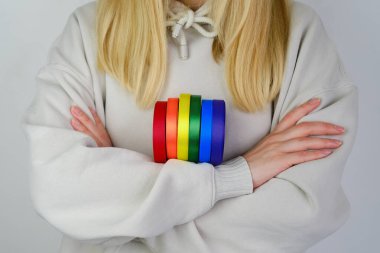 Rainbow LGBT flag from ribbon in the hands of a woman. LGBTQIA Pride Month in June. Lesbian Gay Bisexual Transgender. Gender equality. Human rights and tolerance. Rainbow flag. Love concept