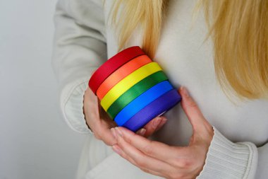 Rainbow LGBT flag from ribbon in the hands of a woman. LGBTQIA Pride Month in June. Lesbian Gay Bisexual Transgender. Gender equality. Human rights and tolerance. Rainbow flag. Love concept