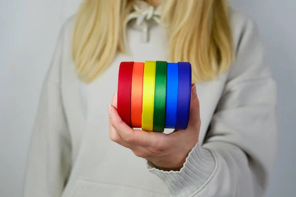 Rainbow LGBT flag from ribbon in the hands of a woman. LGBTQIA Pride Month in June. Lesbian Gay Bisexual Transgender. Gender equality. Human rights and tolerance. Rainbow flag. Love concept