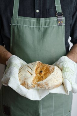 Crispy fresh bread in the hands of a man. Rustic organic wheat bread. Gluten free. Home baking bread closeup. Delicious natural foods, healthy food baking. Small business and slow food concept