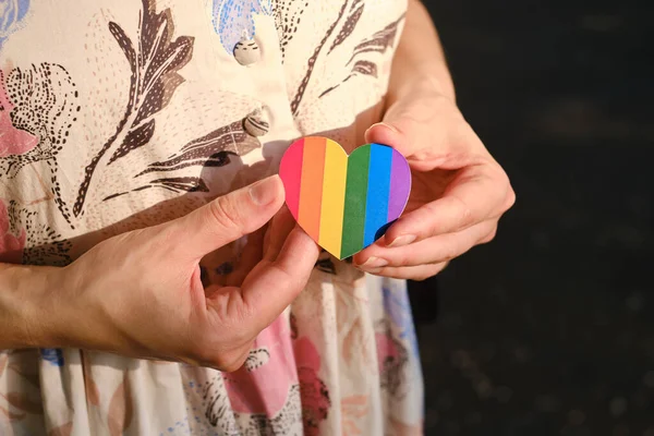 Rainbow heart from paper in woman hands. LGBT flag. LGBTQIA Pride Month in June. Lesbian Gay Bisexual Transgender. Gender equality. Human rights and tolerance. Rainbow flag