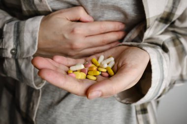 A hand holds an assortment of pills and vitamins close-up. Effective drugs, modern pharmacy for the body and mental health. The concept of healthcare, medicine, pharmacies, disease prevention