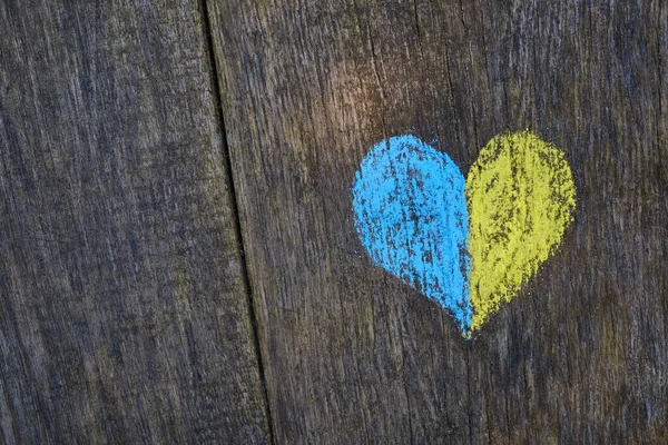 Yellow-blue heart drawn with crayons on a wooden background. Independence of Ukraine. Ukraine love concept. Crayons for drawing. creative background