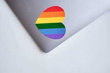 Rainbow heart is pasted on the laptop. LGBT flag. LGBTQIA Pride Month in June. Lesbian gay bisexual transgender. Gender equality. Human rights and tolerance. Rainbow flag