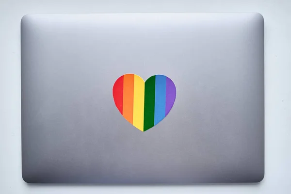 Rainbow heart is pasted on the laptop. LGBT flag. LGBTQIA Pride Month in June. Lesbian gay bisexual transgender. Gender equality. Human rights and tolerance. Rainbow flag