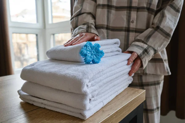 Bath towels in the hands of a girl close up. The woman takes towels and prepares for the body care procedure. Cleanliness concept. Spa treatments at home in a beauty salon or in hotels