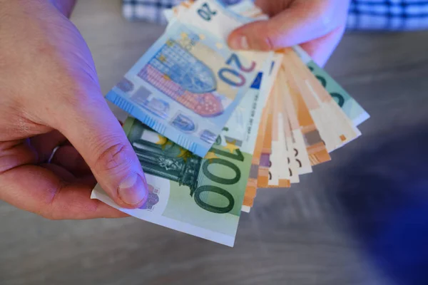 Man holds money in his hands. Cash in euro for payment or exchange. Male counts salary in euro banknotes. Saving money, withdrawal banking deposit. European money. Financial crisis. Hands close-up