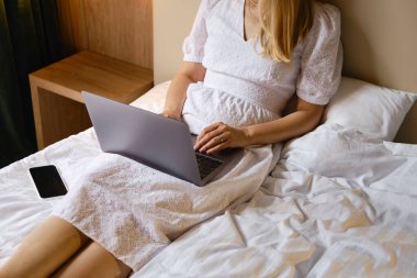 Kız evde ya da otellerde dizüstü bilgisayar ve akıllı telefonla çalışıyor. Mesafeli iş. Ofis evde. Yatak odasındaki kadın dizüstü bilgisayarda yazıyor, uzaklardan öğreniyor, internette sörf yapıyor.